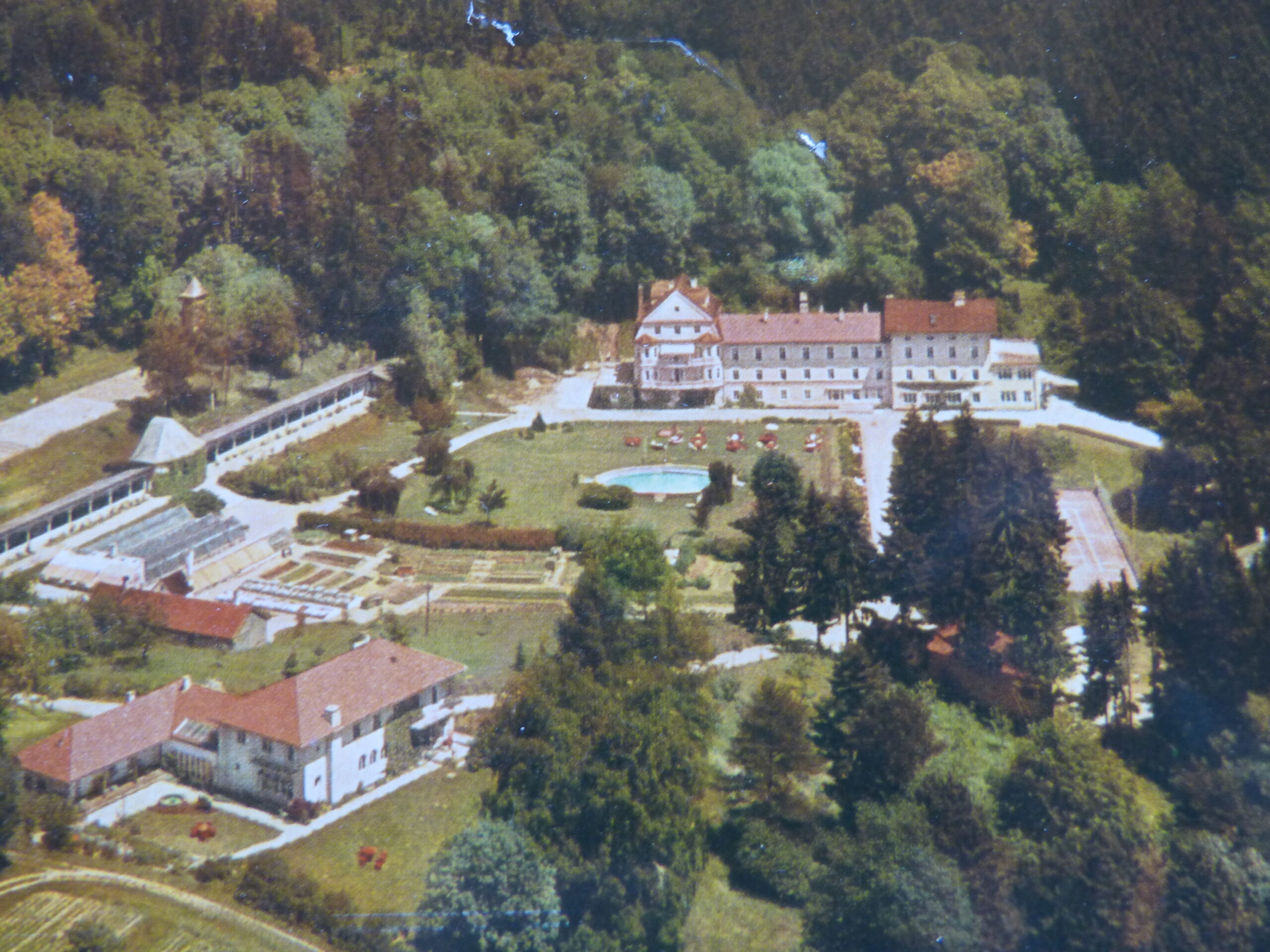 Historische Aufnahme der Klinik Wartenberg, auf der die Klinik nur aus dem Altbau und der heute nicht mehr existierenden Liegehalle besteht. Man erkennt den Springbrunnen in der Mitte des Geländes. Vorne links im Bild sieht man das Haus Irmgard.