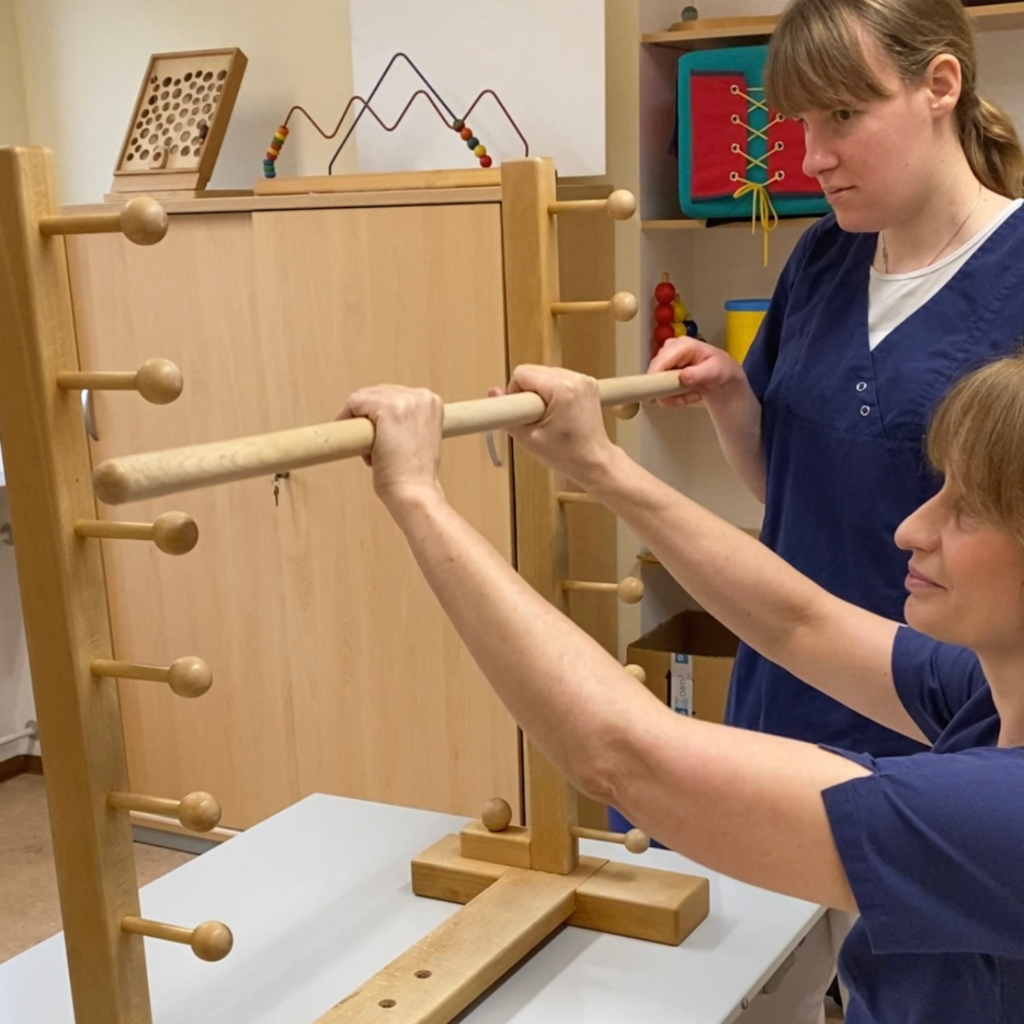 Bild der Ergotherapie die ein neues Holz Hilfsmittel ausprobieren