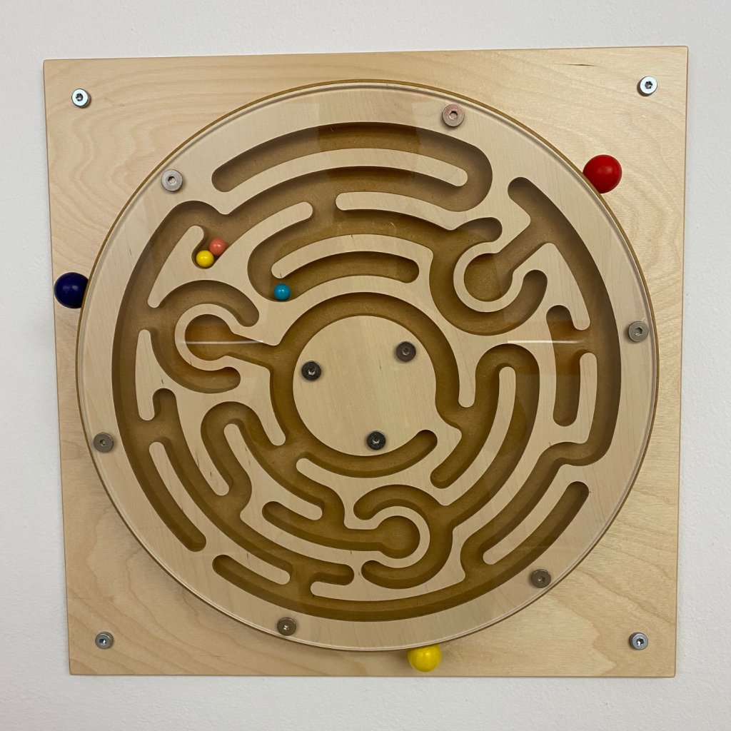 Bild eines Geschicklichkeitsspieles, bei dem man drei kleine Kugeln durch ein rundes, drehbares Holzlabyrinth führen muss.